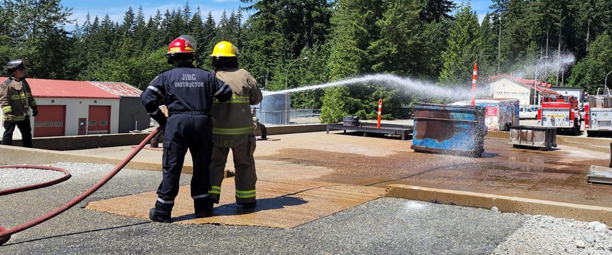 Participants in Indigenous Youth Career Camp at JIBC learn to use a fire hose at the Maple Ridge campus.