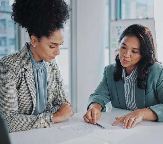 2 women in a meeting room discussing