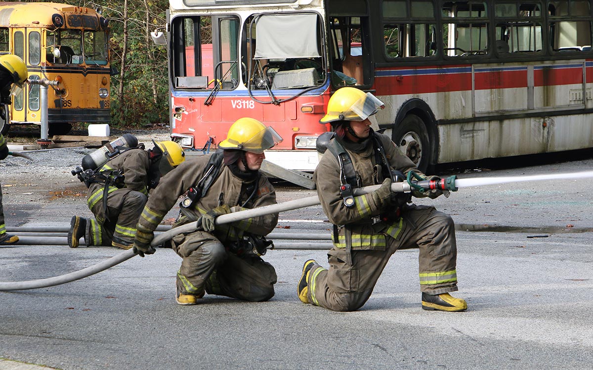 Deryck Lafortune, left, assists in holding the firehose during a demonstration at JIBC’s Maple Ridge campus.