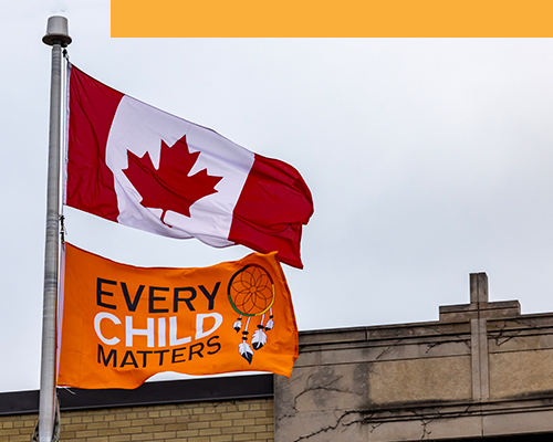 An orange Every Child Matters flag from the Canadian National Day for Truth and Reconciliation with a Canadian flag.