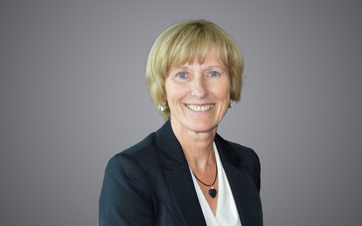 Head and shoulders photo of woman wearing dark jacket and white blouse.