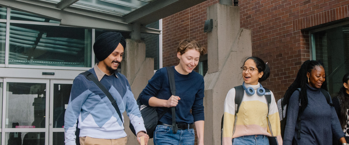 A group of students standing in front of a JIBC campus building.