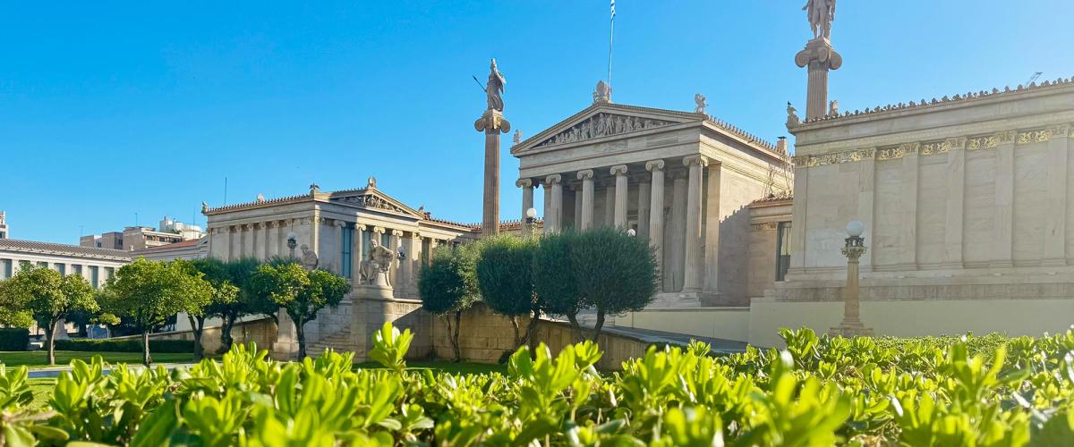 Old Greek building with pillars in the distance.