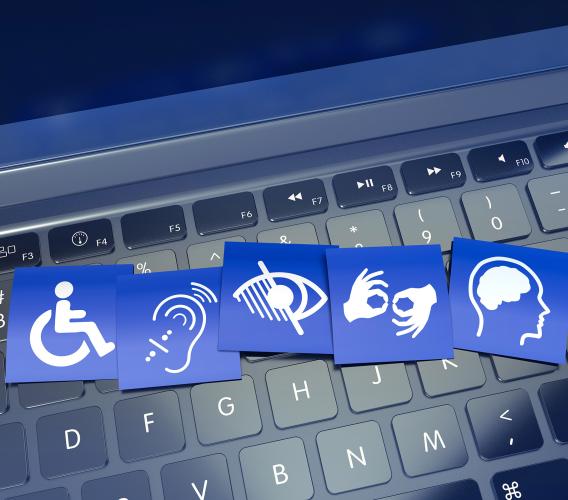 Blue cards with symbols of accessibility needs on top of black keyboard.