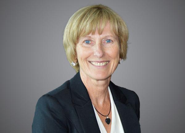 Head and shoulders photo of woman wearing dark jacket and white blouse.