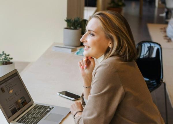 women smiling on macbook
